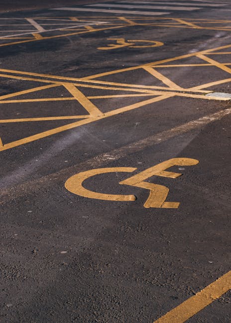 A row of five loading bays attached to a bright yellow building, each bay having a black canopy with white identification labels reading B56, B57, B58, B59, and B60. The loading bays feature closed si