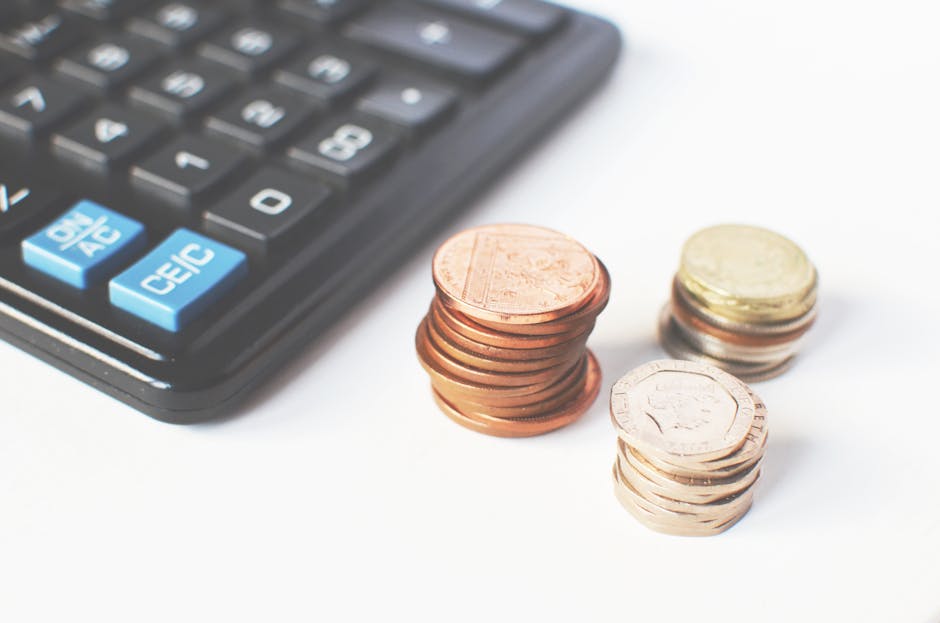 An open brown cardboard moving box positioned on a flat surface with a property bill or invoice partially visible inside, showing numerical currency amounts. A person's hand, wearing a dark suit sleev